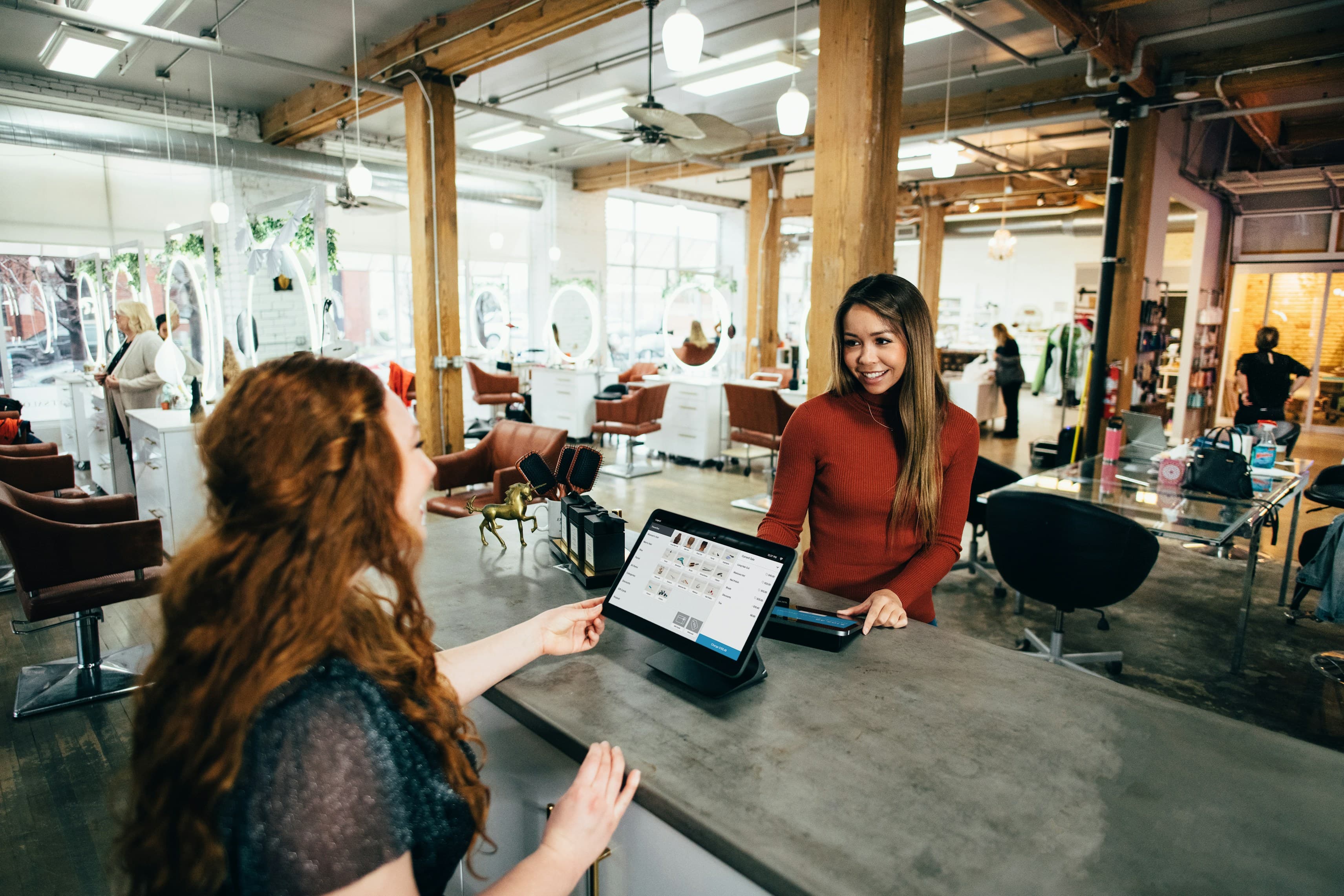 A client checking in at a modern salon front desk