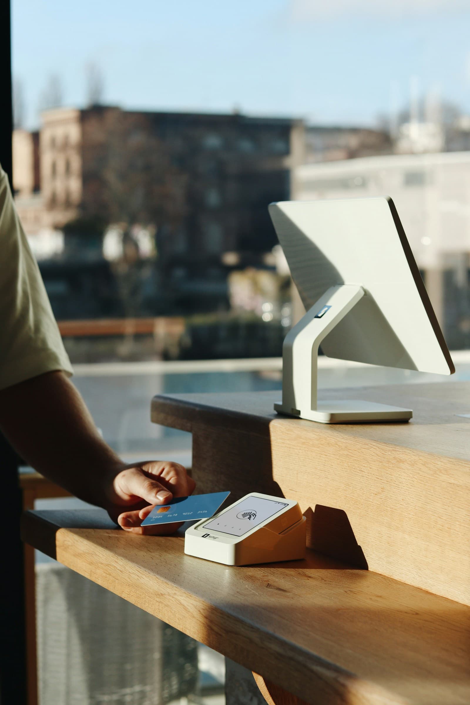 Client tapping a card on a contactless terminal at checkout